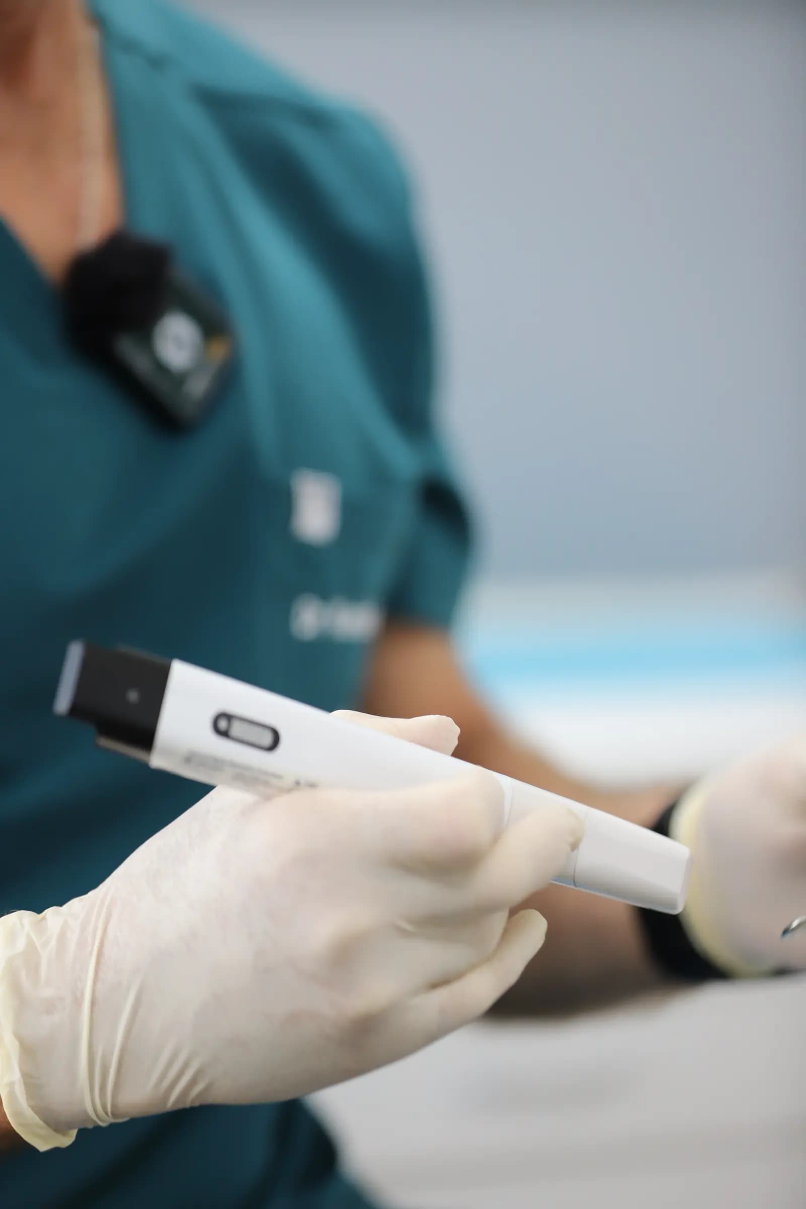 Gloved hand holding an intraoral scanner