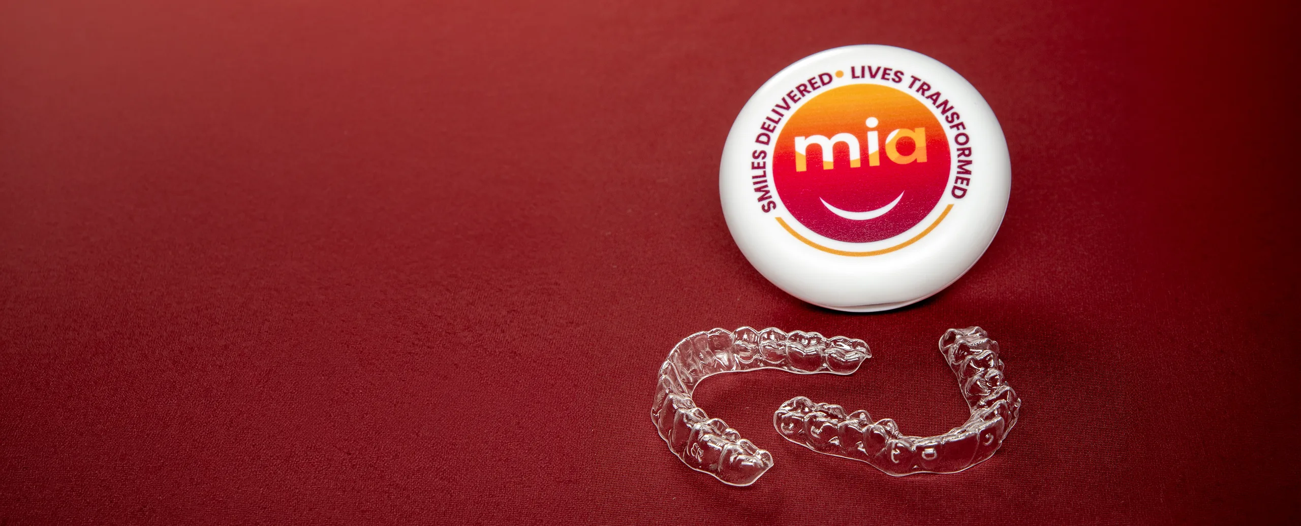 Clear aligner trays beside a Mia case